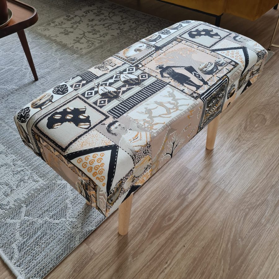 Handmade upholstered bench footstool with African-print patchwork fabric and wooden legs
