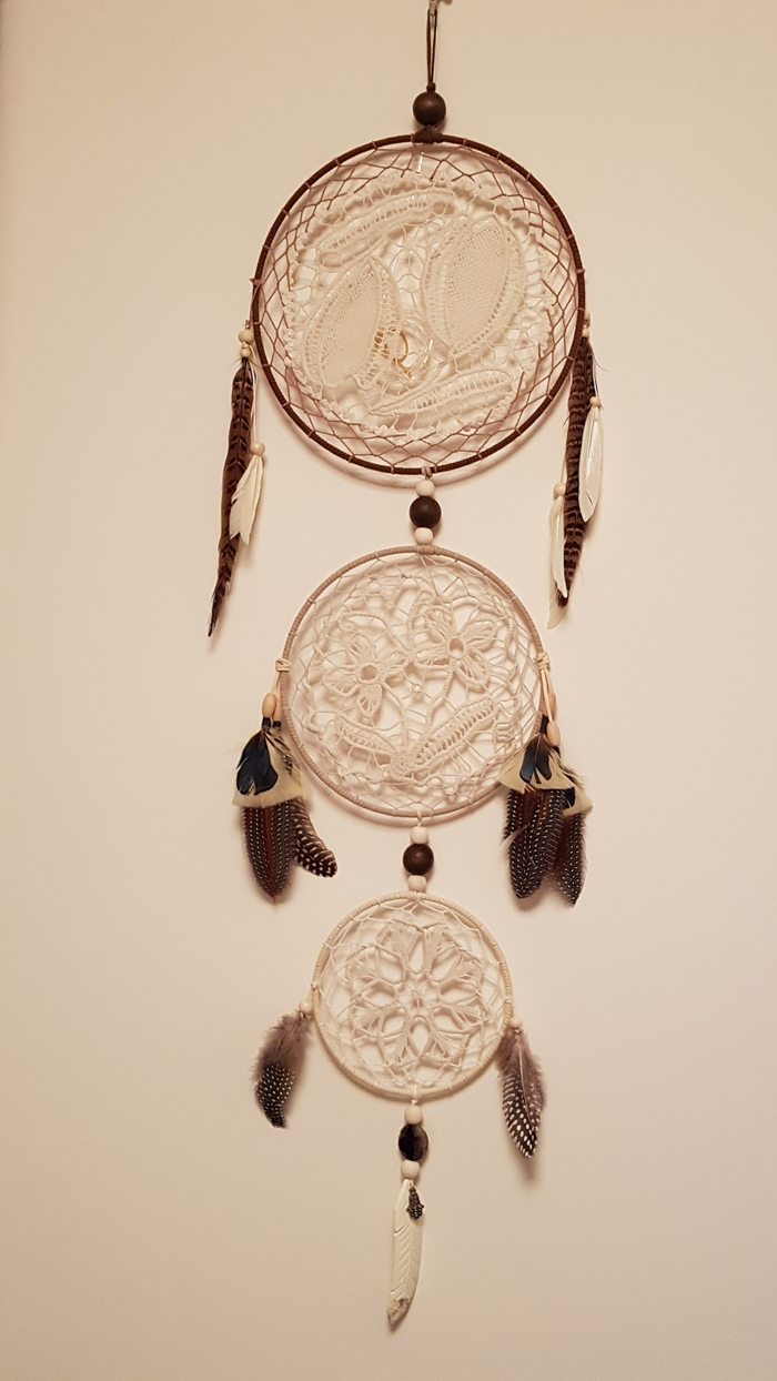 Dreamcatcher made from three generations of hand-crocheted doilies, with feathers and wooden beads
