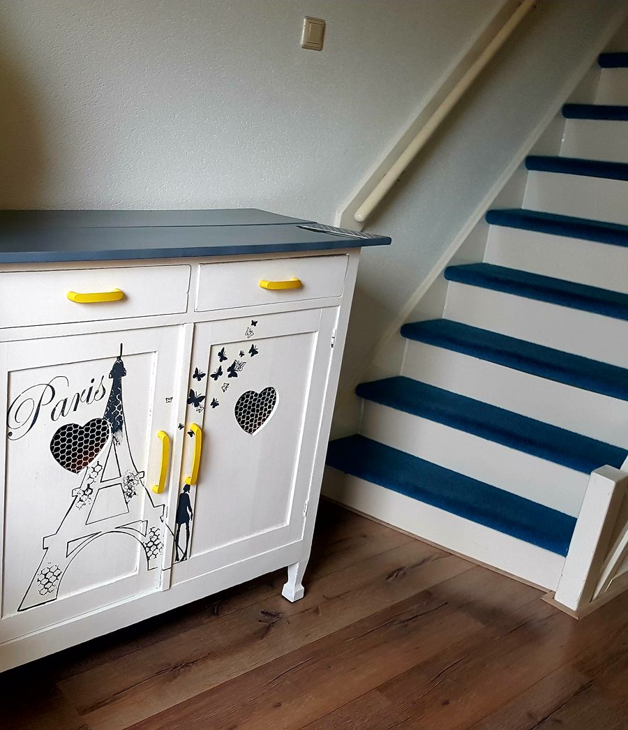 Upcycled cabinet with hand-drawn Paris and Eiffel Tower design, styled as hallway shoe storage