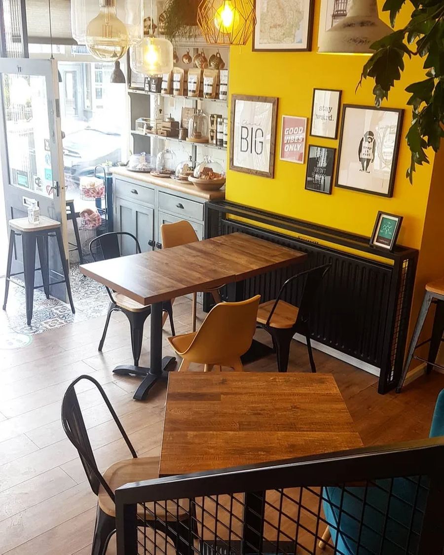 Dining tables and yellow gallery wall seating area at Daniel's Bistro