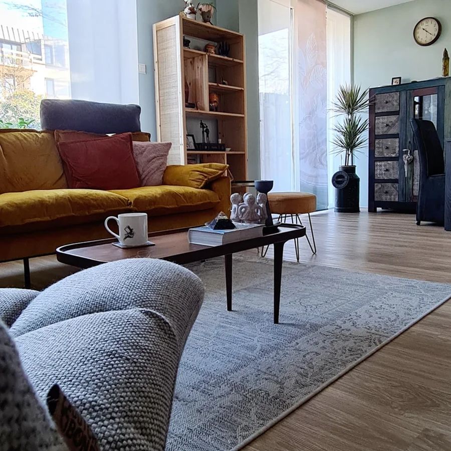 Wide view of the bohemian living room with mustard velvet sofa